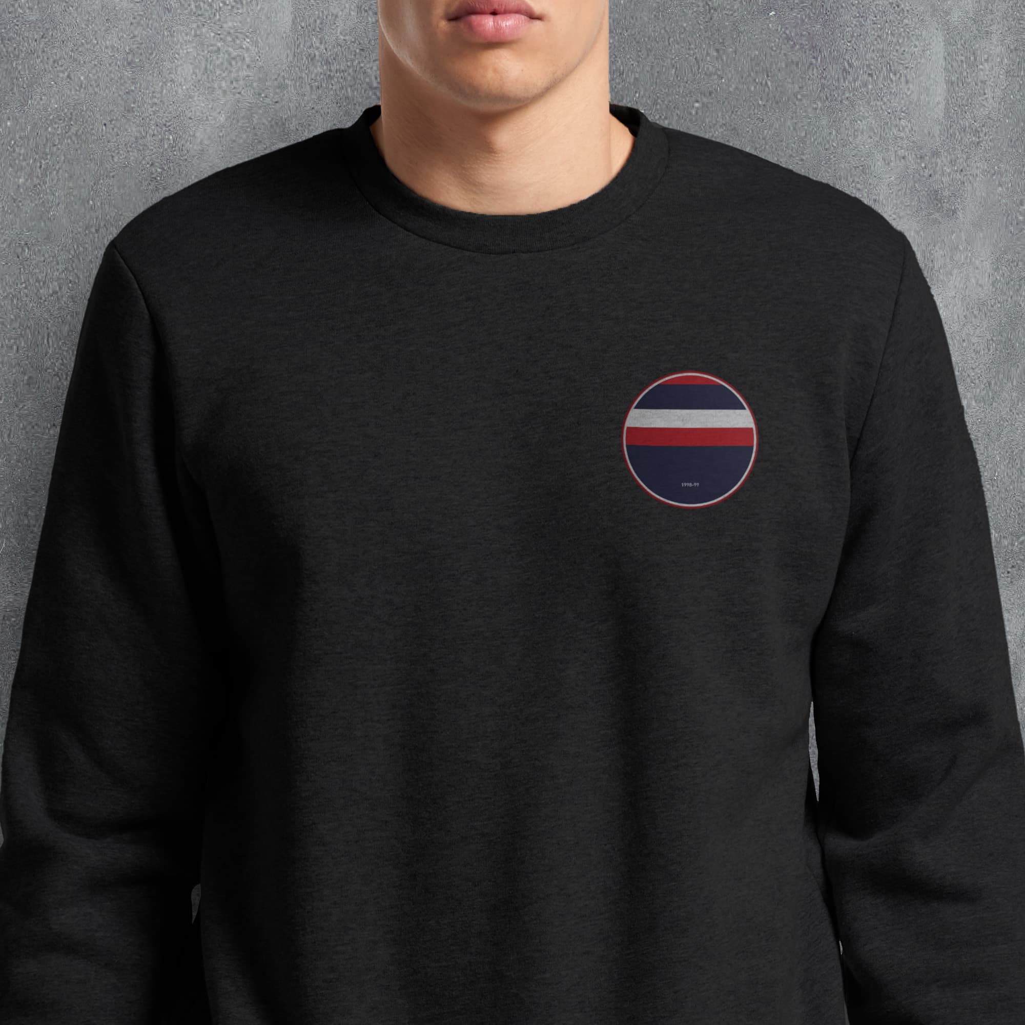 a man wearing a black sweatshirt with a red, white, and blue circle patch