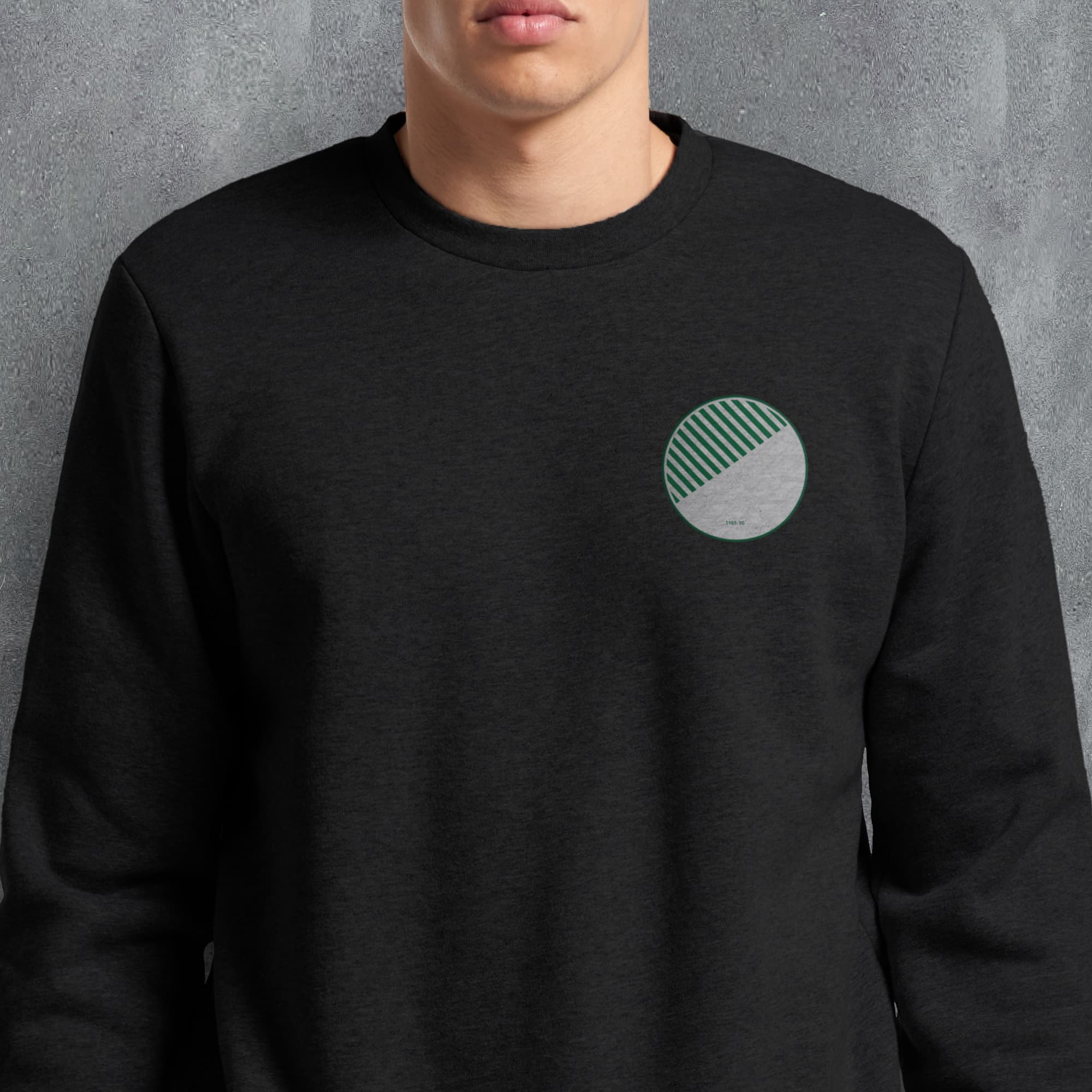 a man wearing a black sweatshirt with a green circle on it