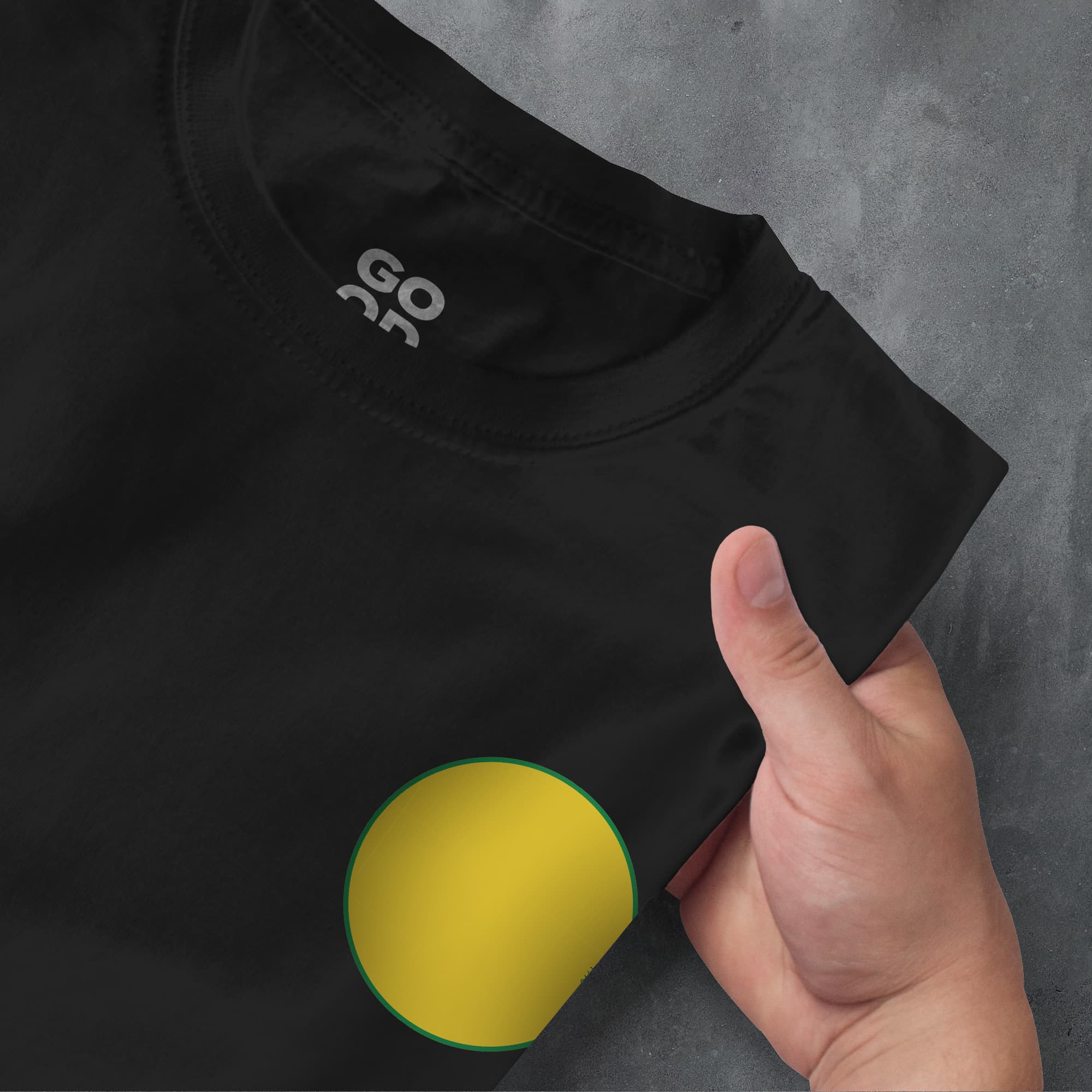 a person pointing at a black shirt with a yellow circle on it