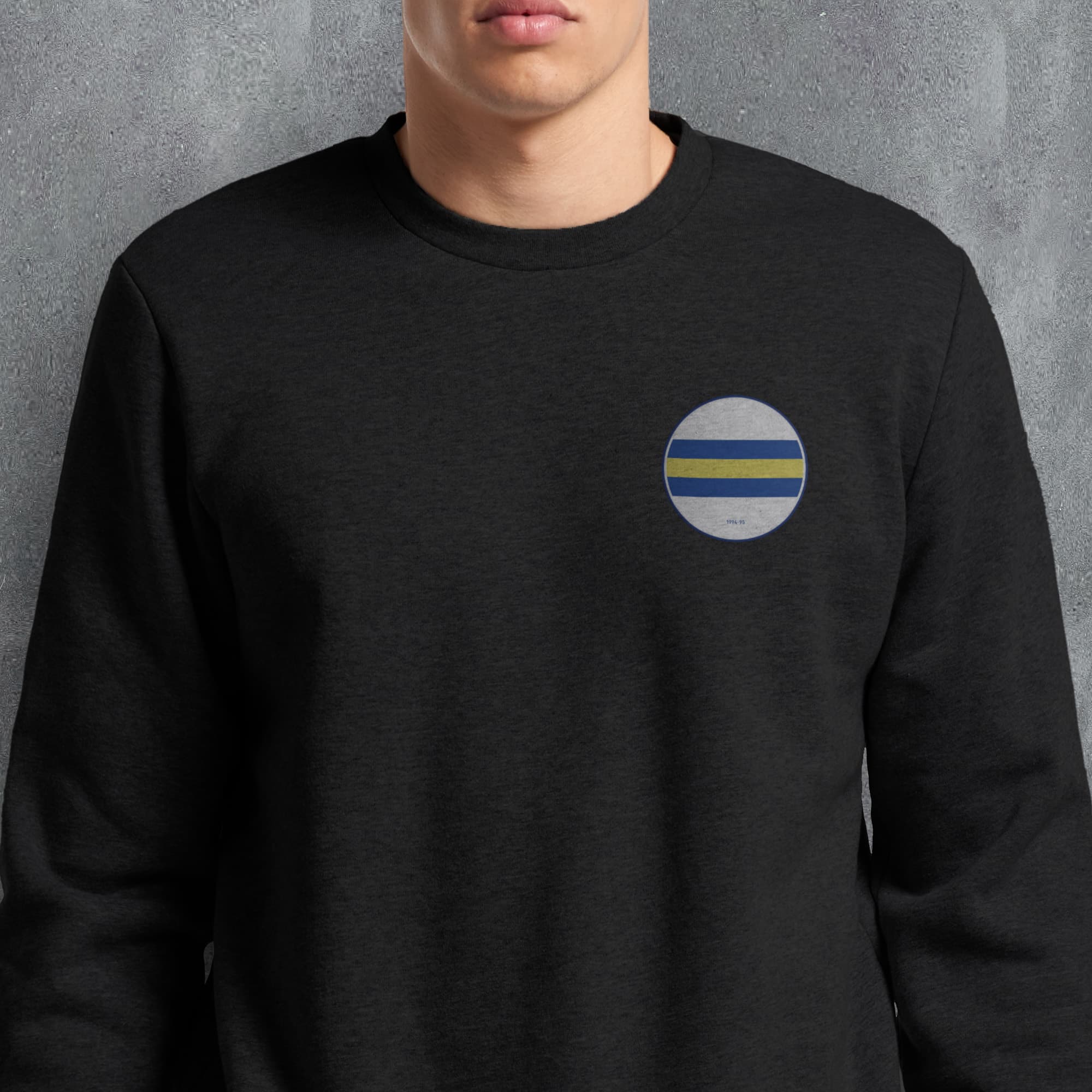 a man wearing a black sweatshirt with a blue, yellow and white stripe on the