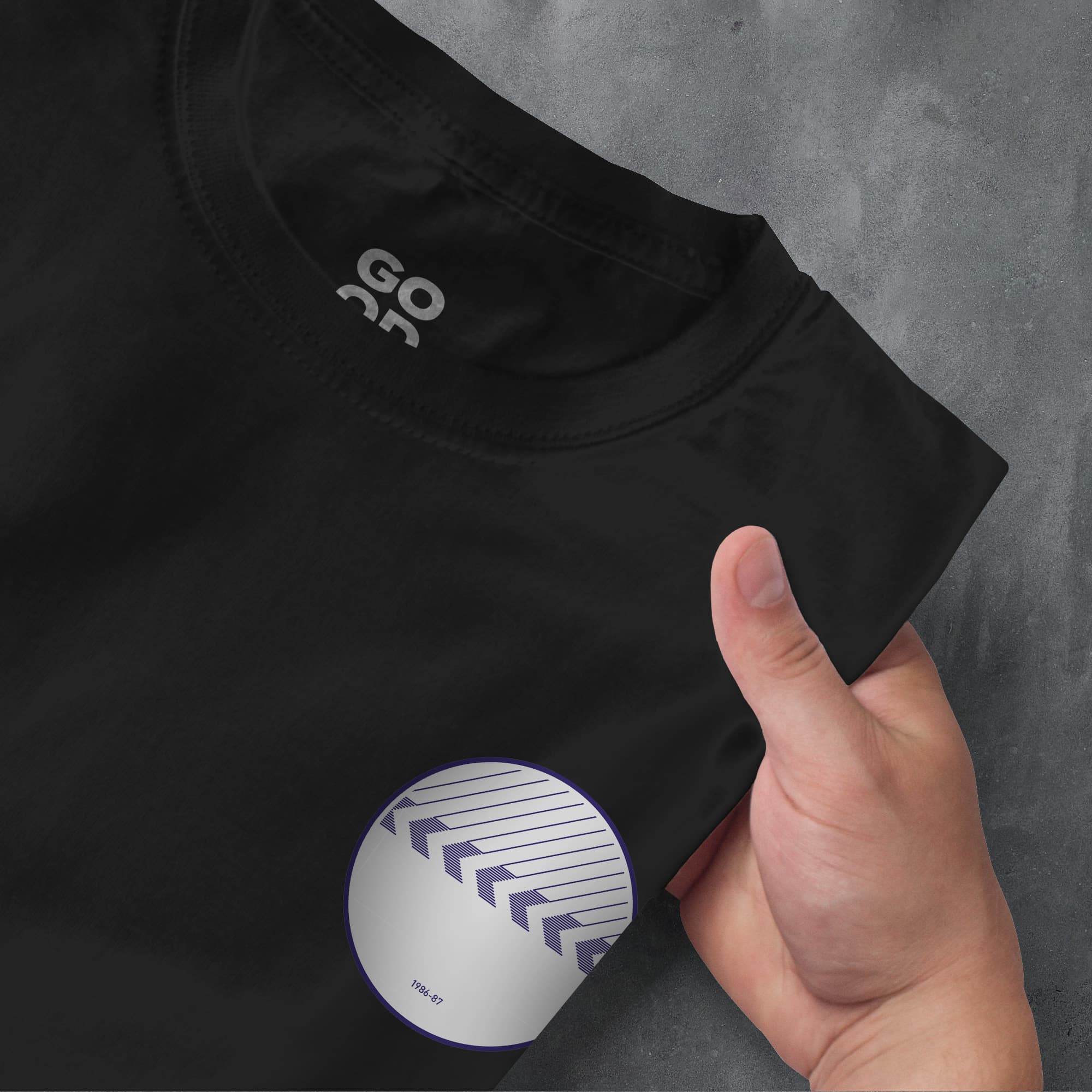 a hand pointing at a t - shirt with the word go as printed on it