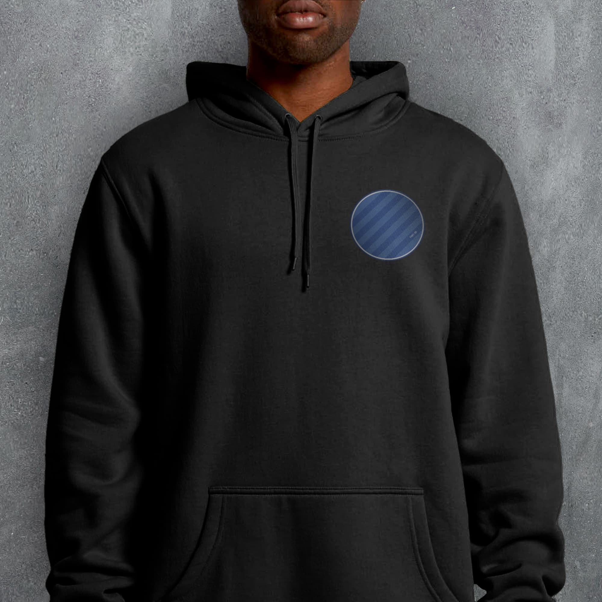 a man wearing a black hoodie with a blue circle on it