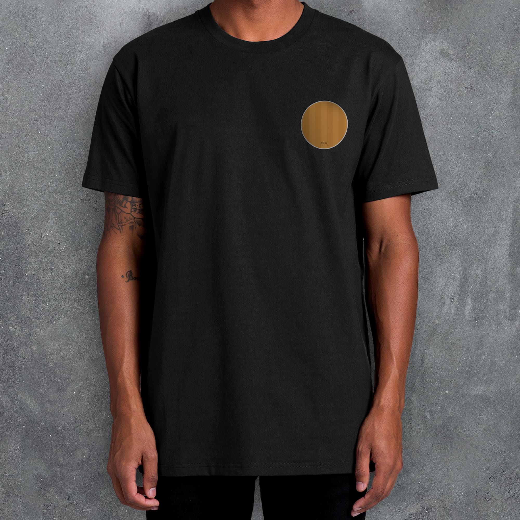 a man wearing a black t - shirt with a gold circle on it