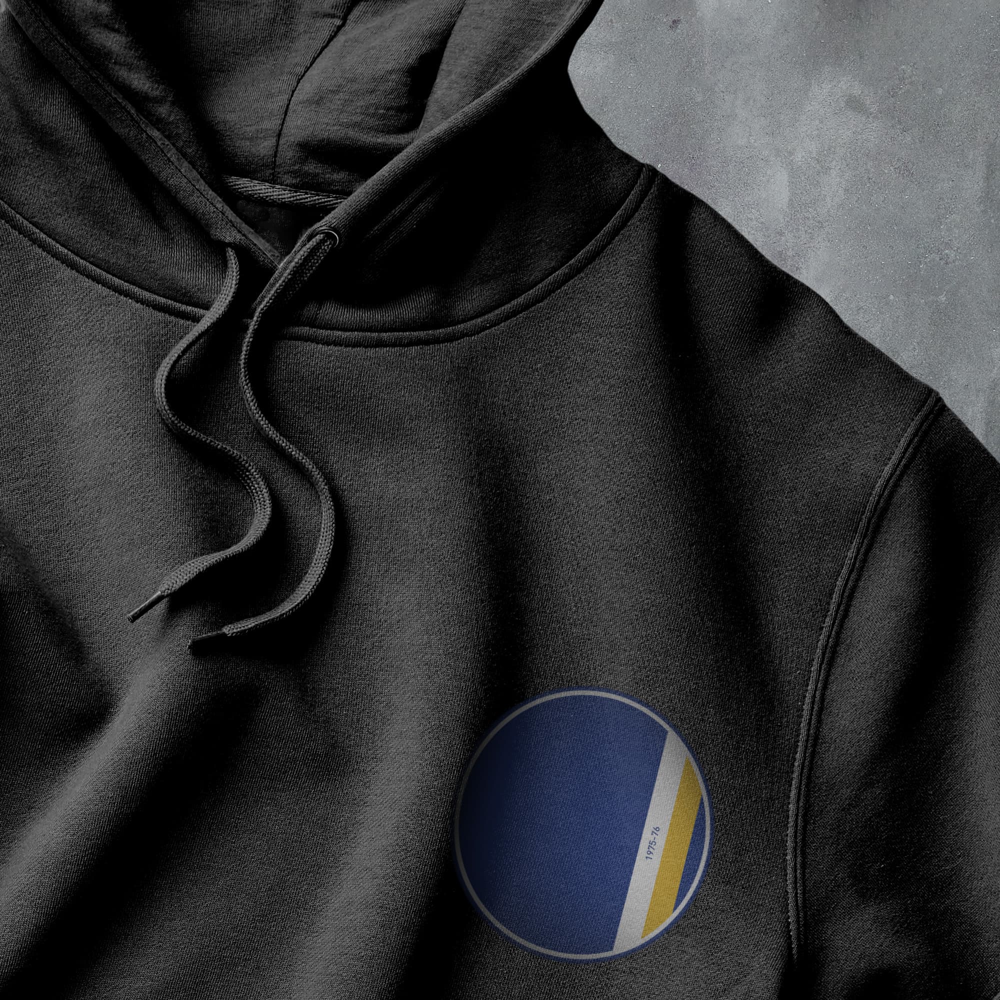 a black hoodie with a yellow and blue circle on it