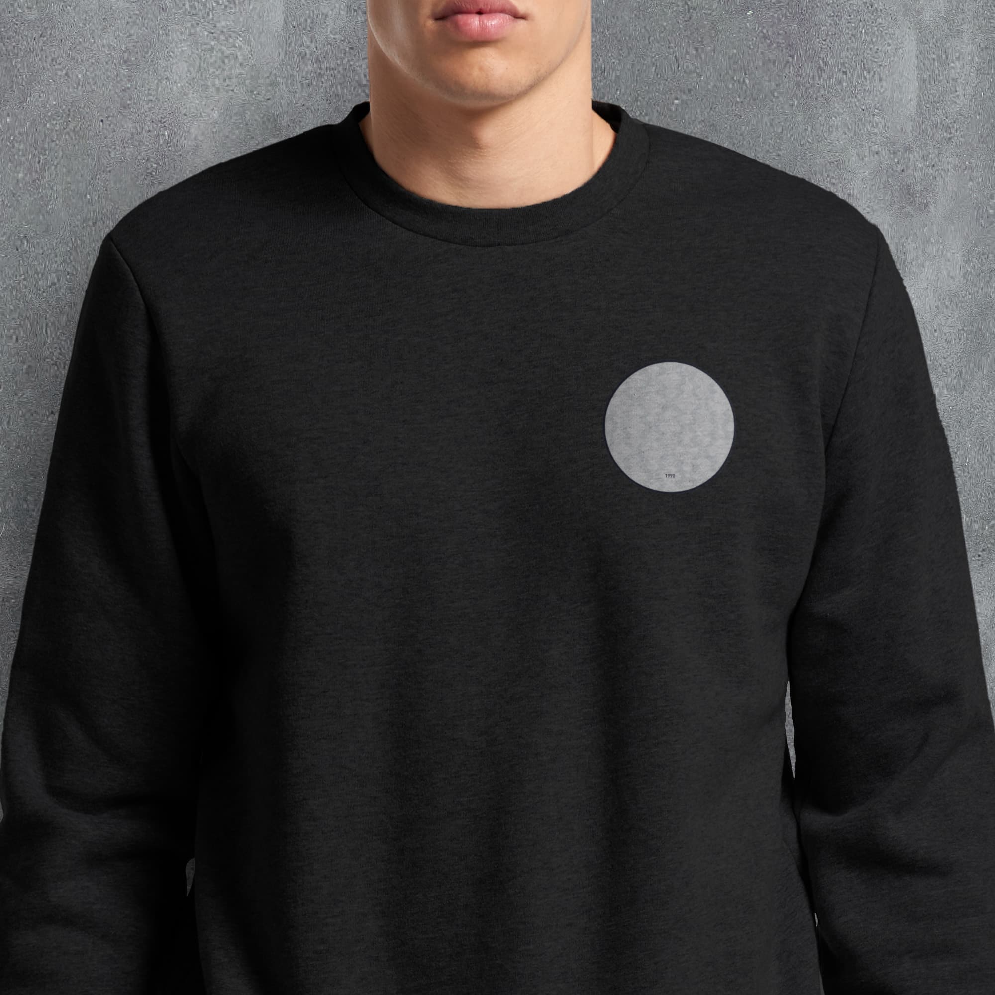 a man wearing a black sweatshirt with a white circle on it
