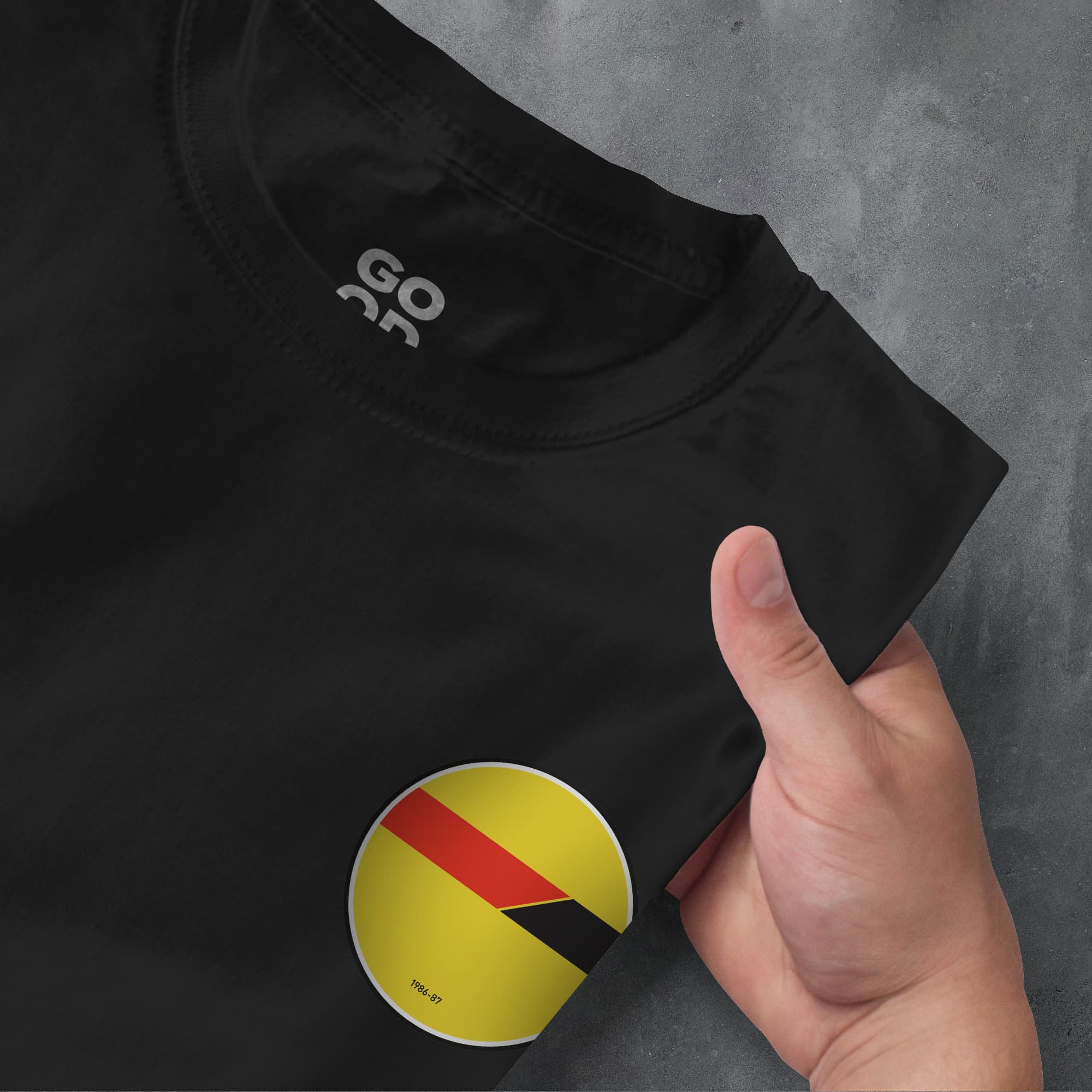 a person holding a black shirt with a red and yellow stripe on it