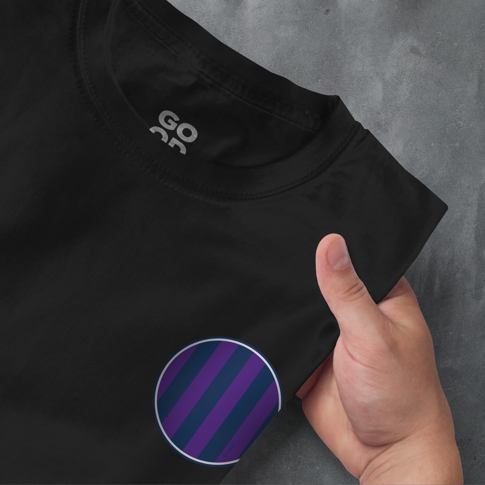 a hand pointing at a black shirt with purple stripes