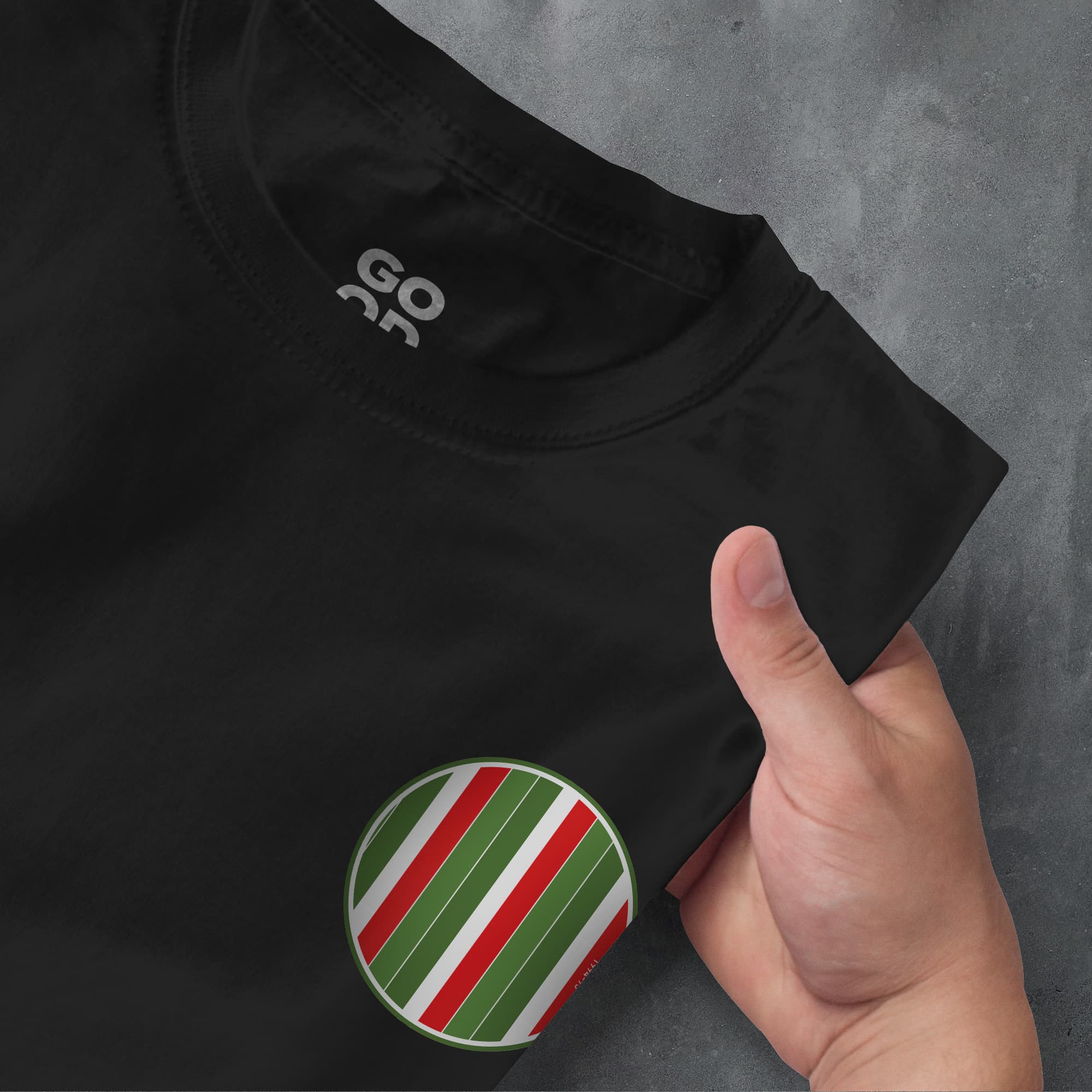 a person pointing at a black shirt with a green and red stripe on it