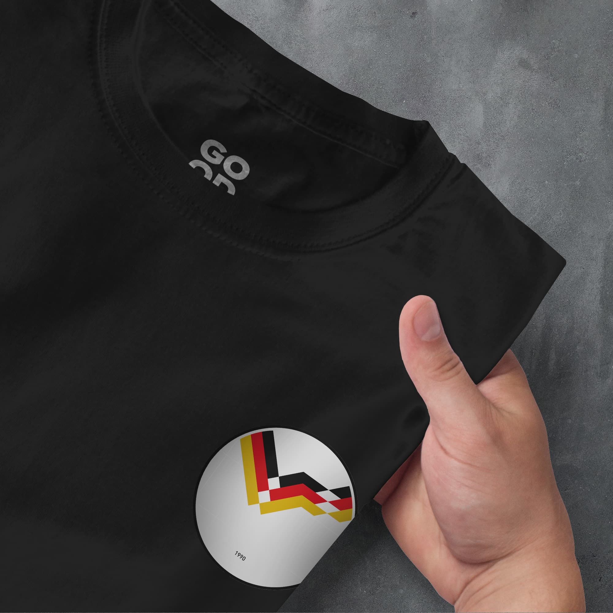 a person's hand pointing at a t - shirt with the german flag on