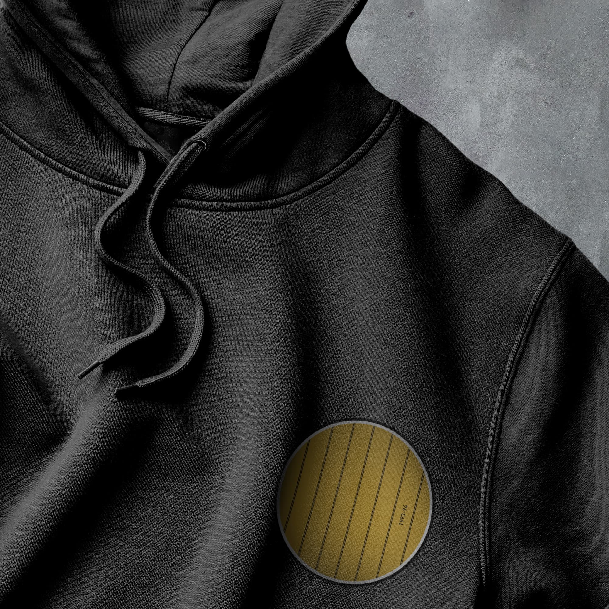 a close up of a black hoodie with a yellow patch