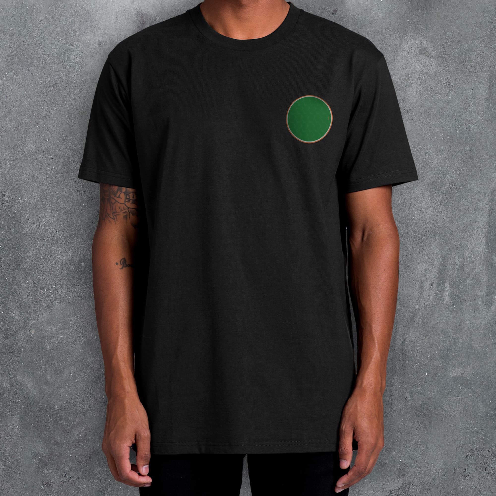 a man wearing a black t - shirt with a green circle on it