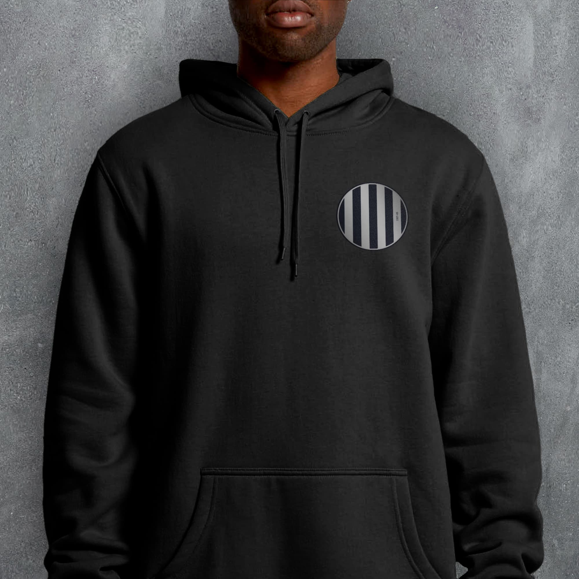 a man wearing a black hoodie with a black and white striped circle on the