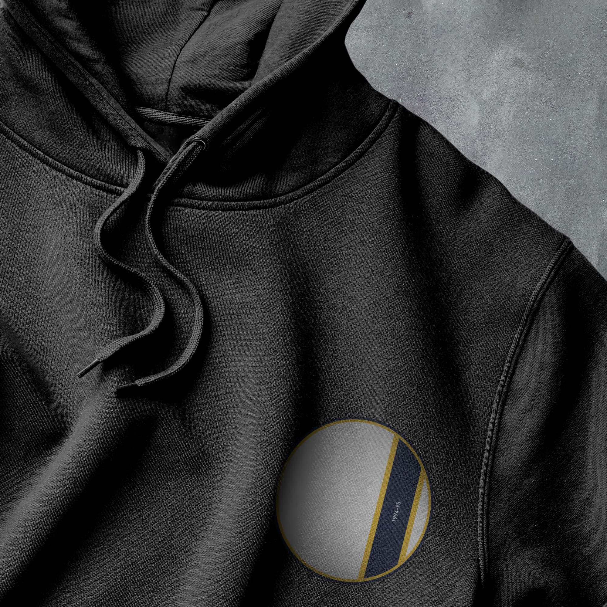 a black hoodie with a white and yellow circle on it