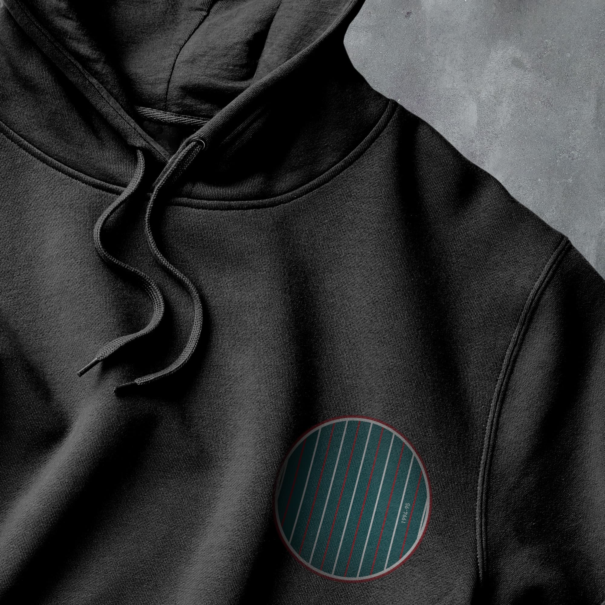 a close up of a black hoodie with a red circle on it