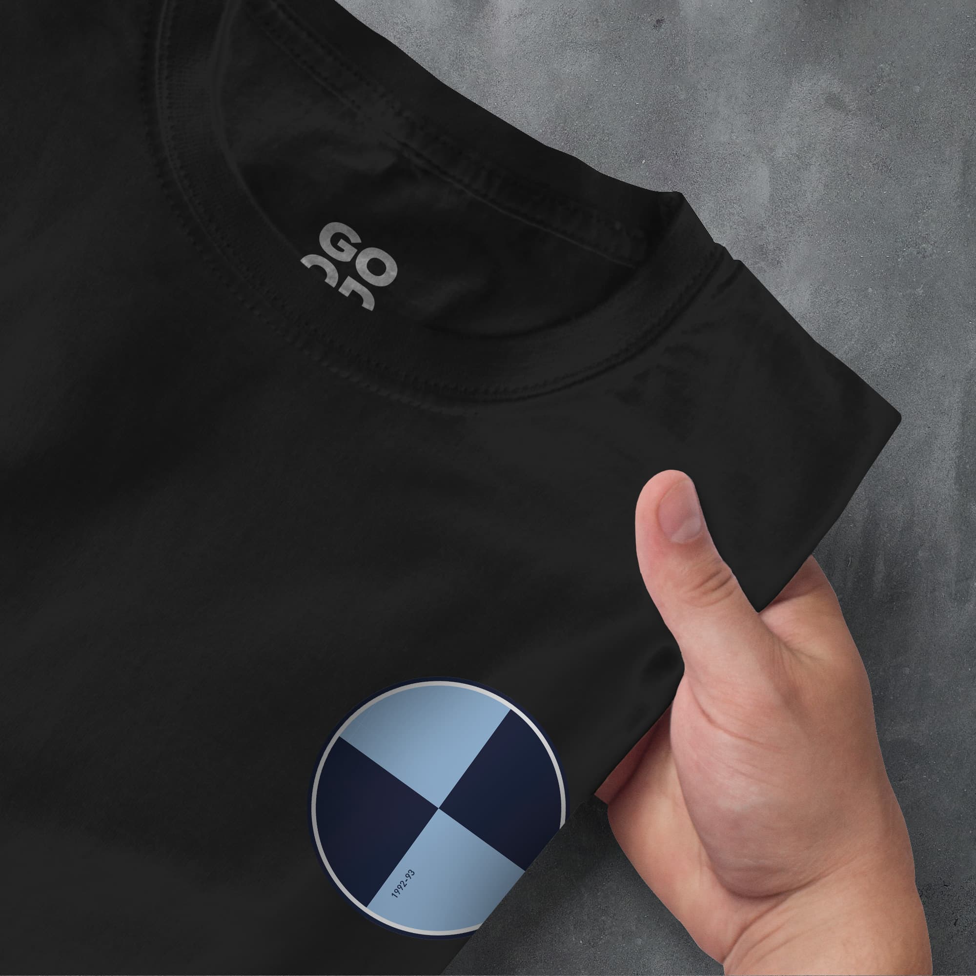 a hand pointing at a black shirt with a blue cross on it