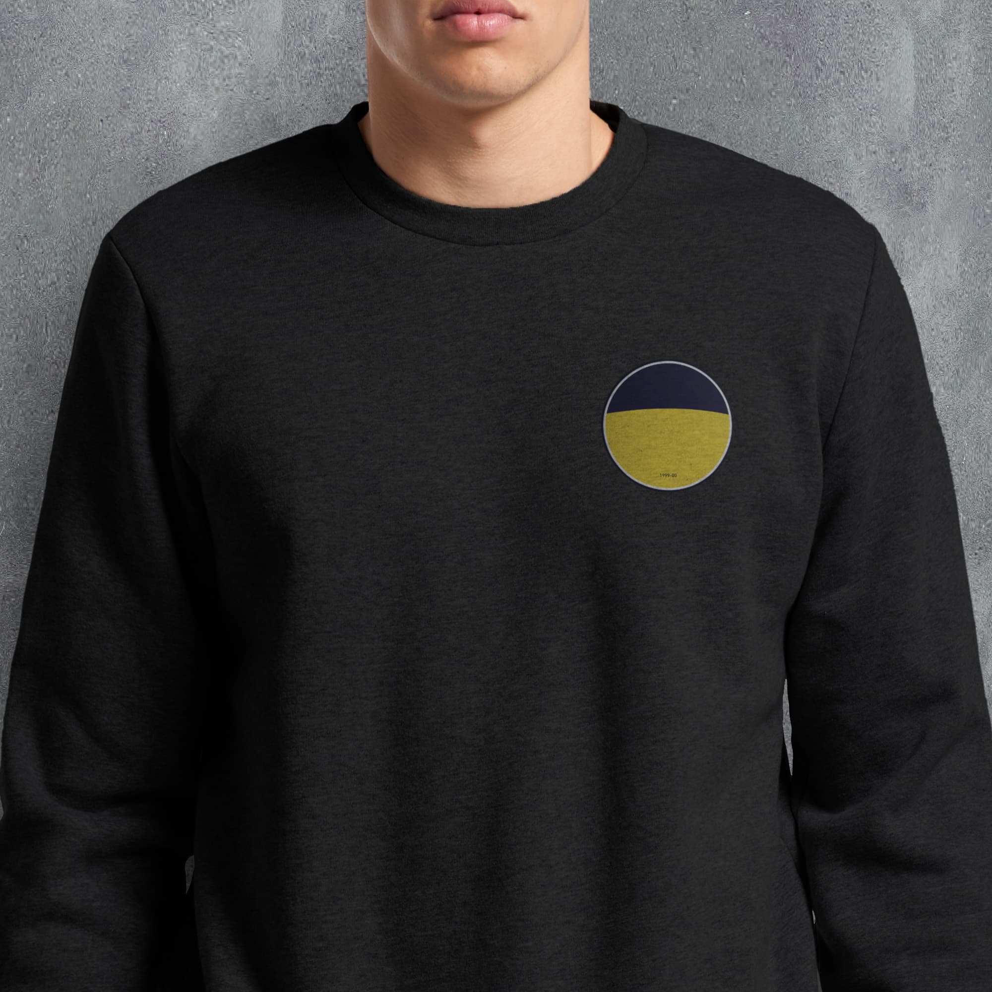 a man wearing a black sweatshirt with a yellow and blue circle on it