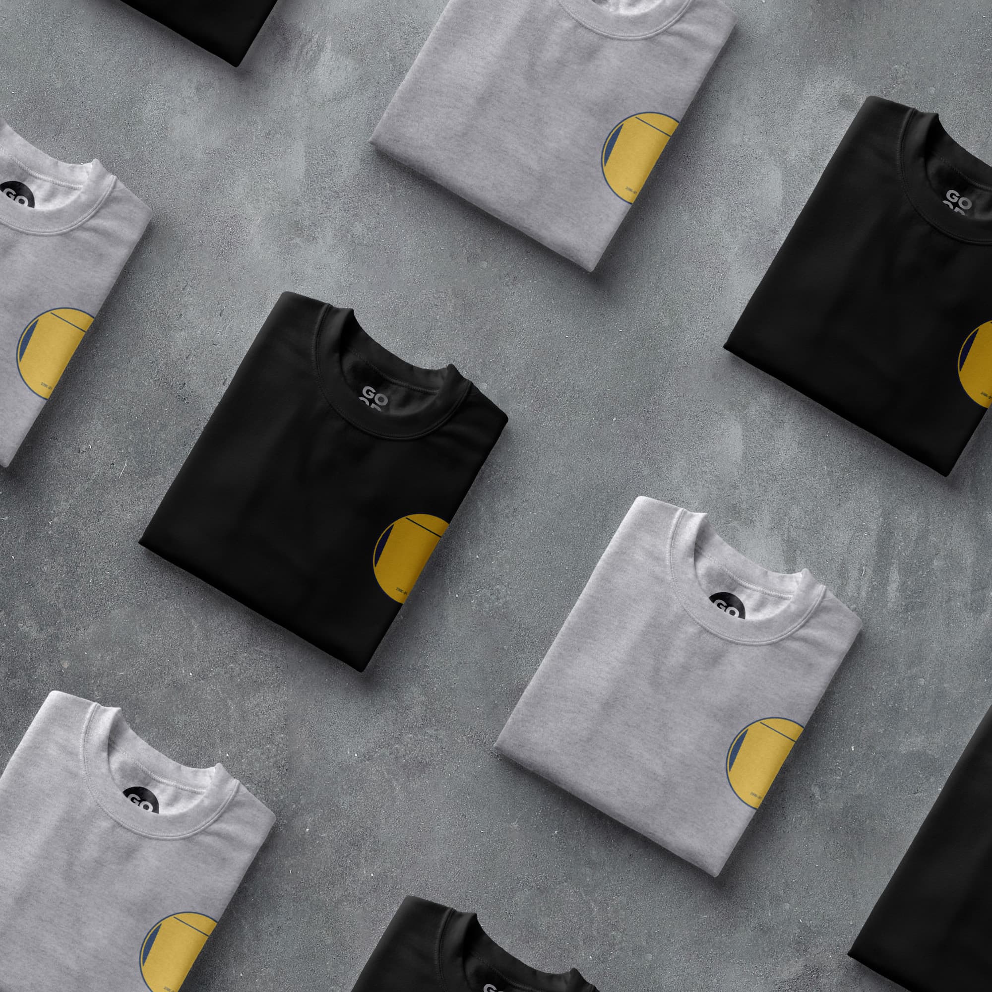 a group of black and white t - shirts with yellow patches