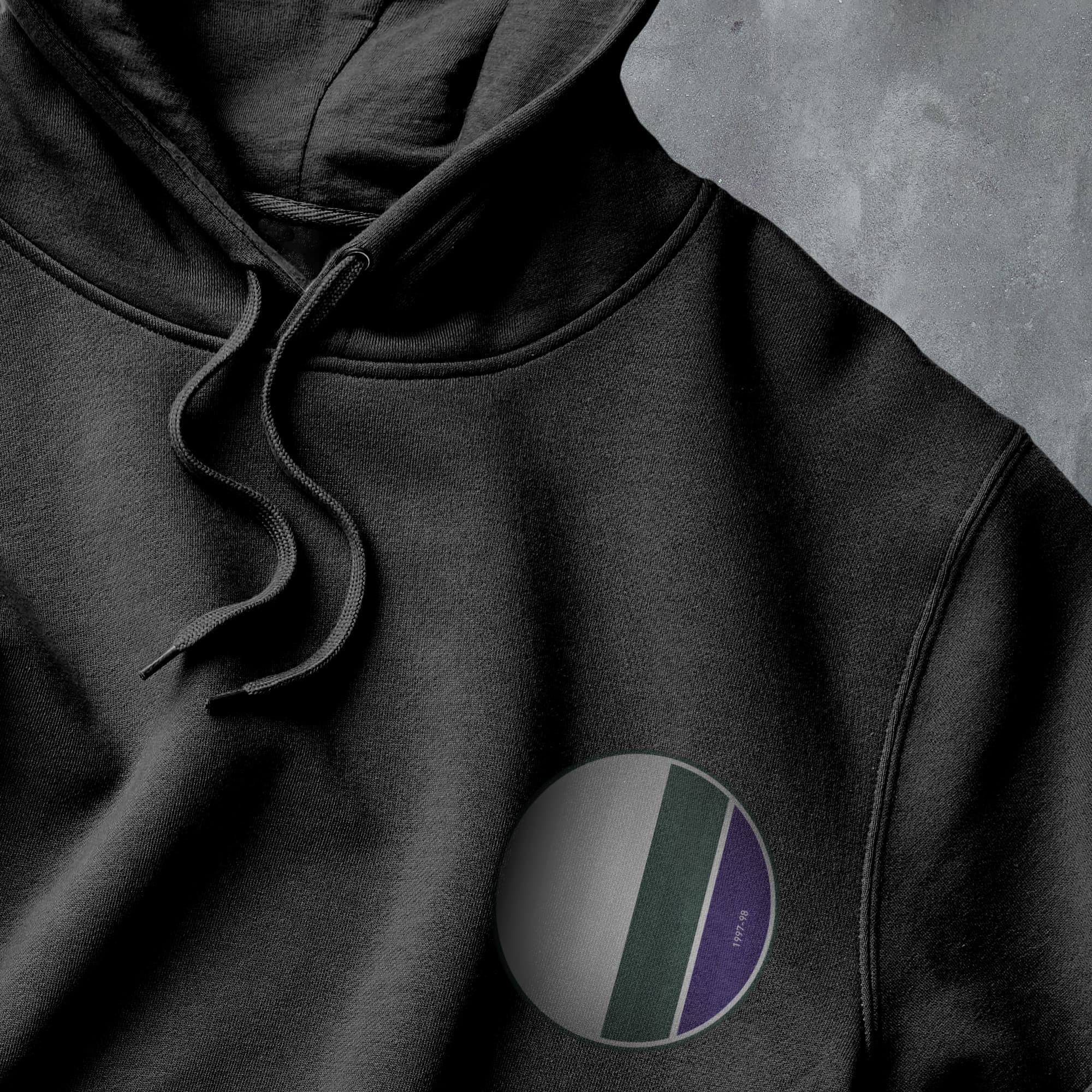 a black hoodie with a purple and green circle on it