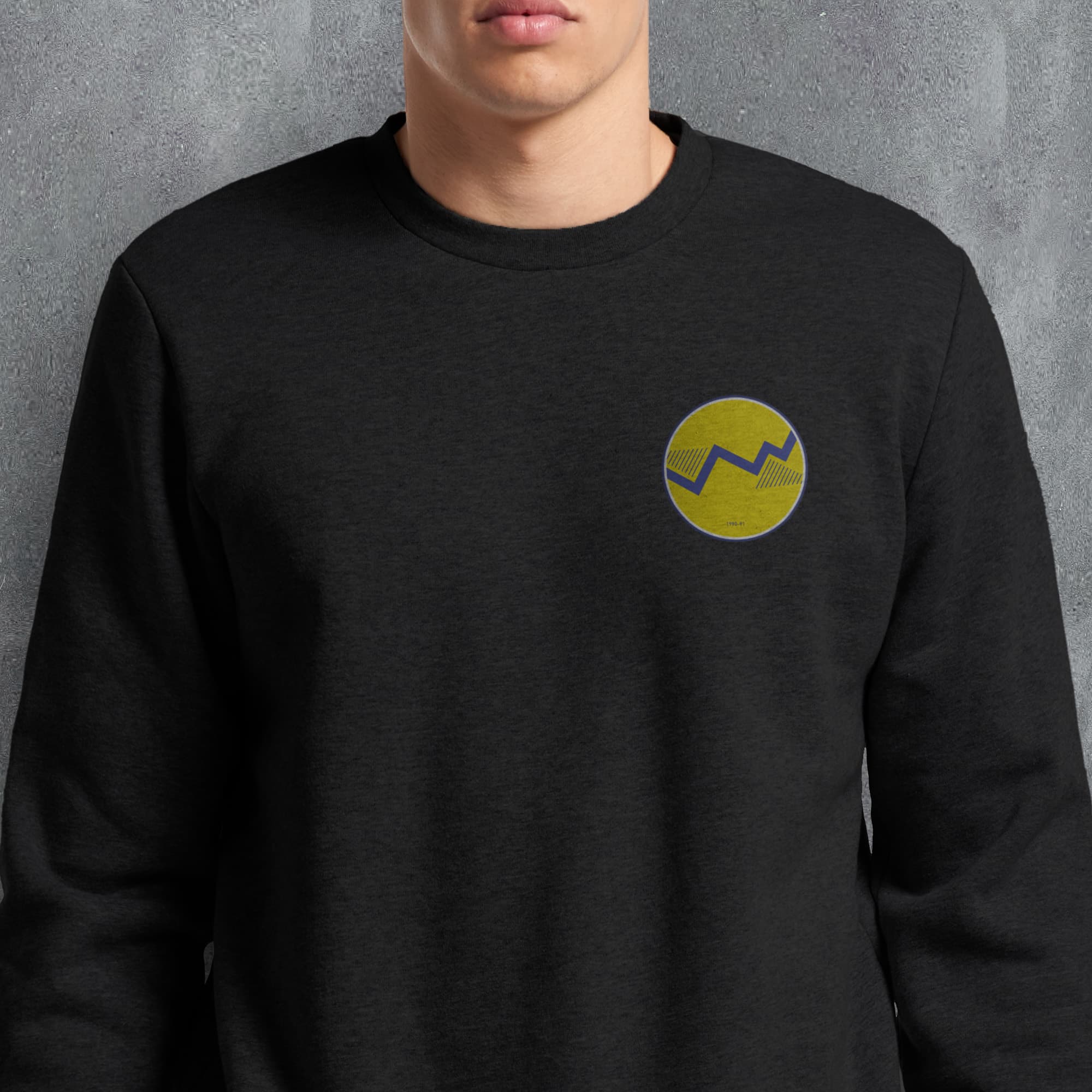 a man wearing a black sweatshirt with a yellow smiley face