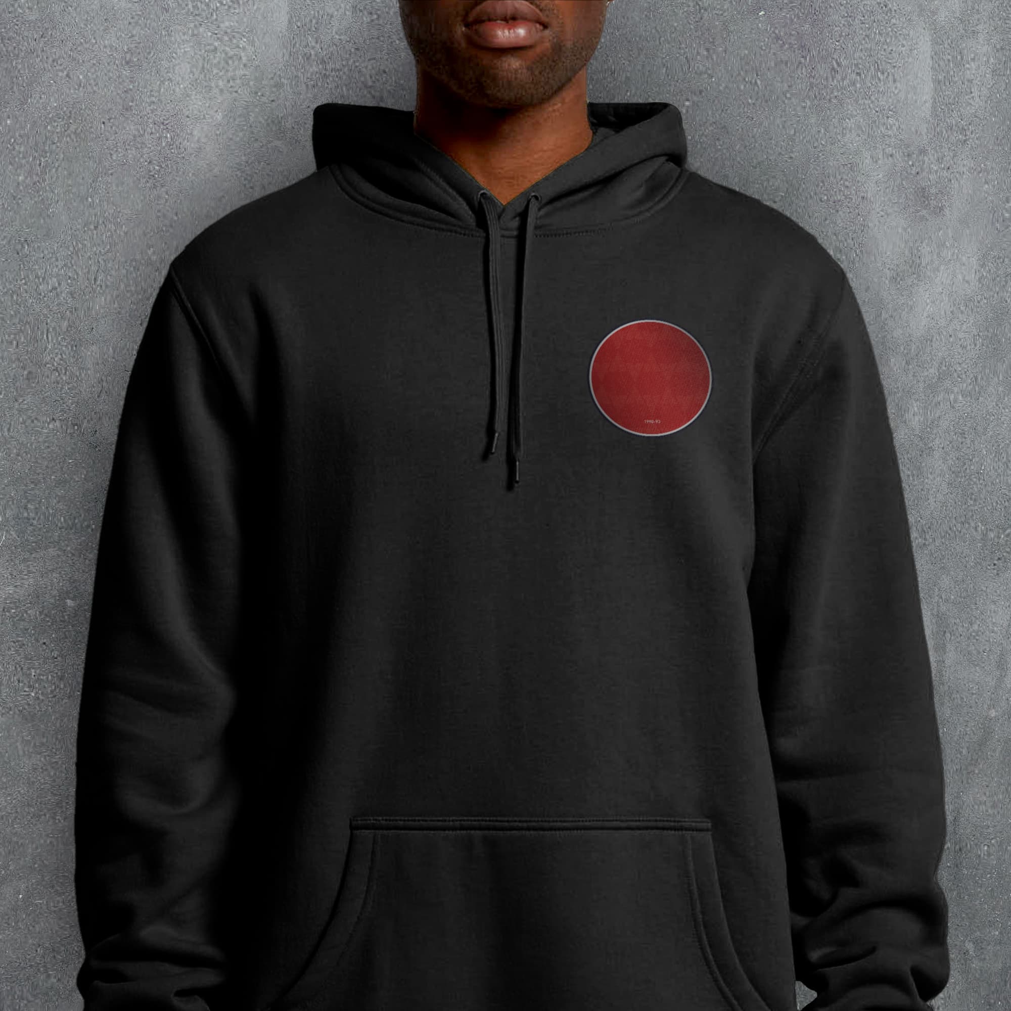 a man wearing a black hoodie with a red circle on it