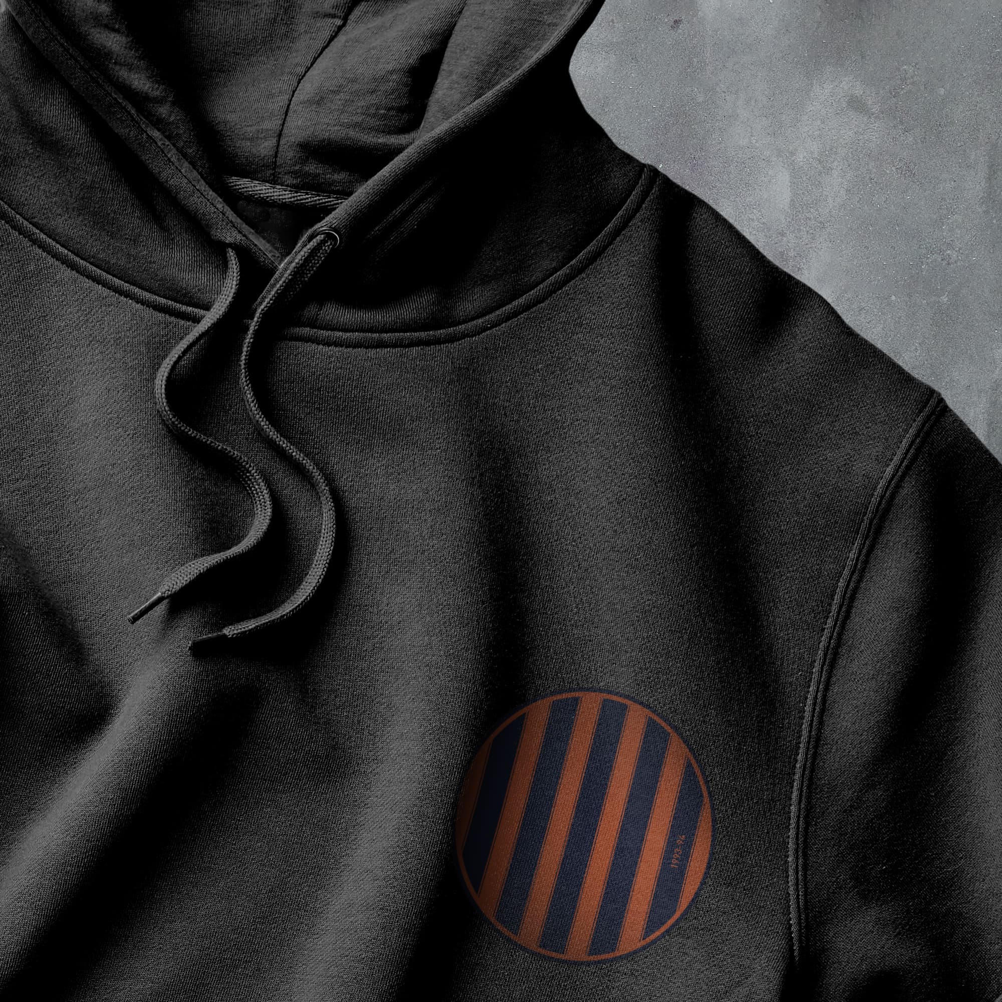 a close up of a black hoodie with an orange stripe on it