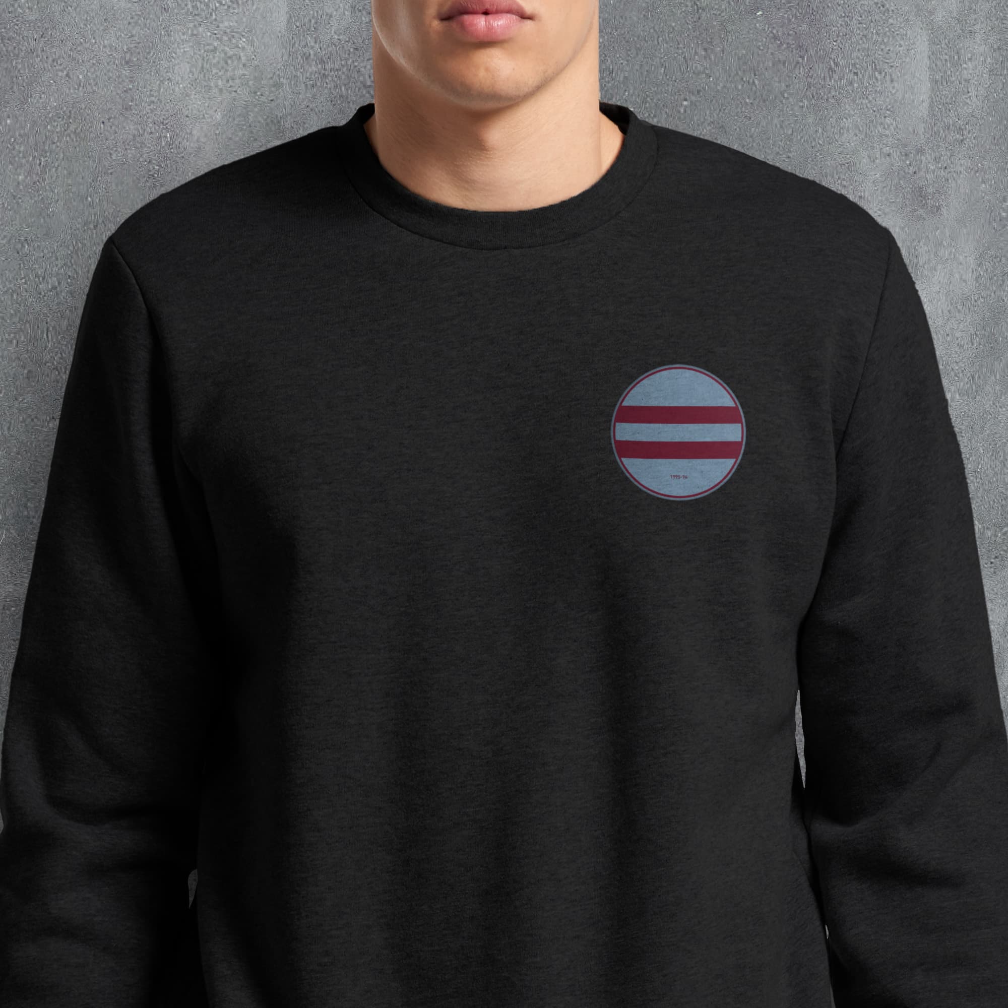 a man wearing a black sweatshirt with a red, white, and blue circle patch