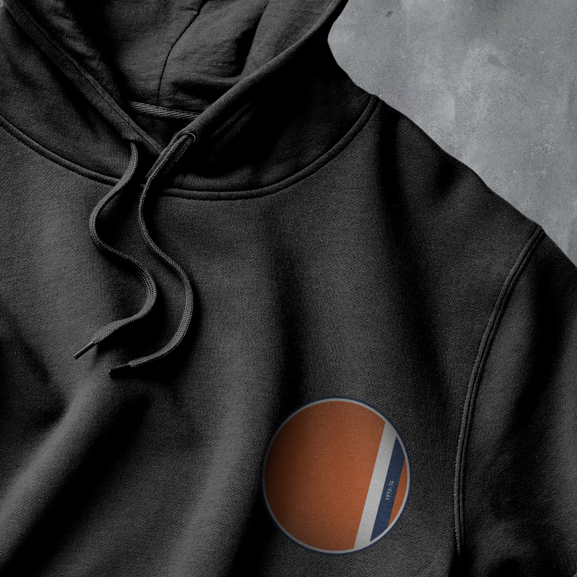 a black hoodie with an orange, white and blue stripe on it