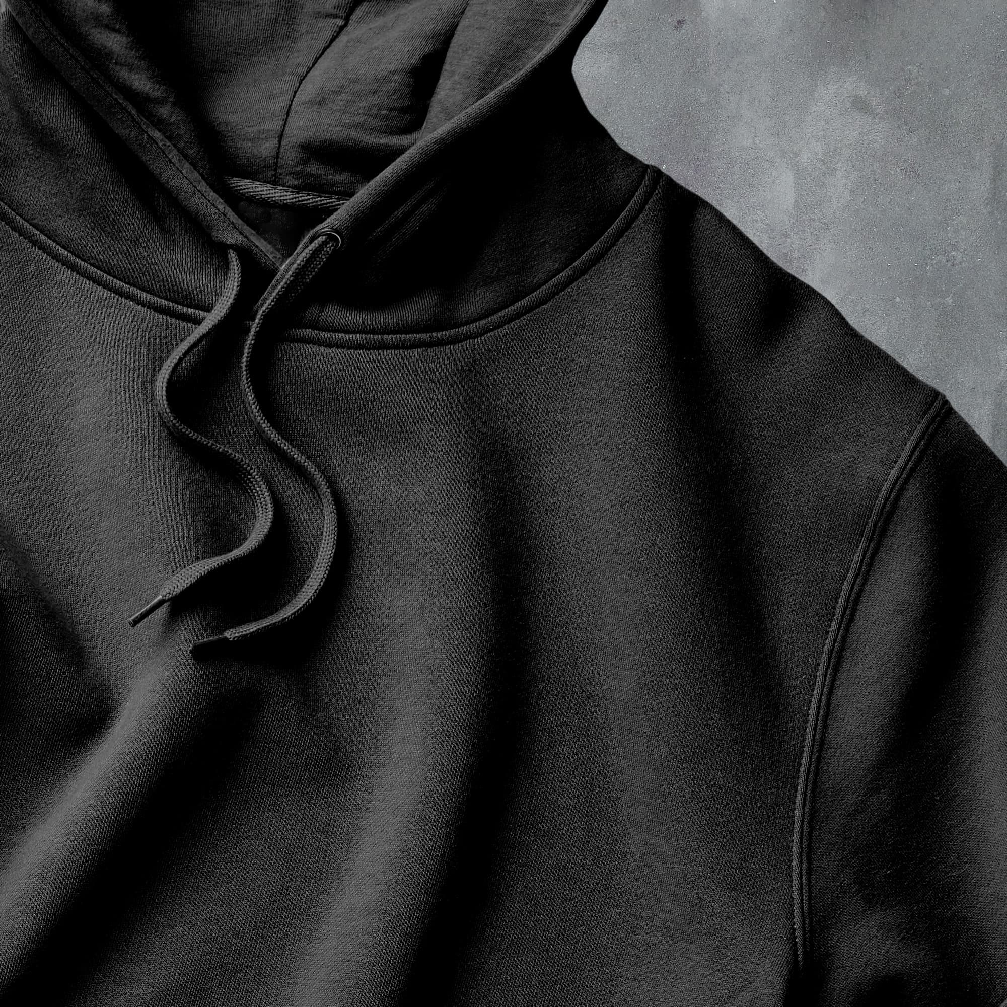 a close up of a black hoodie on a gray background