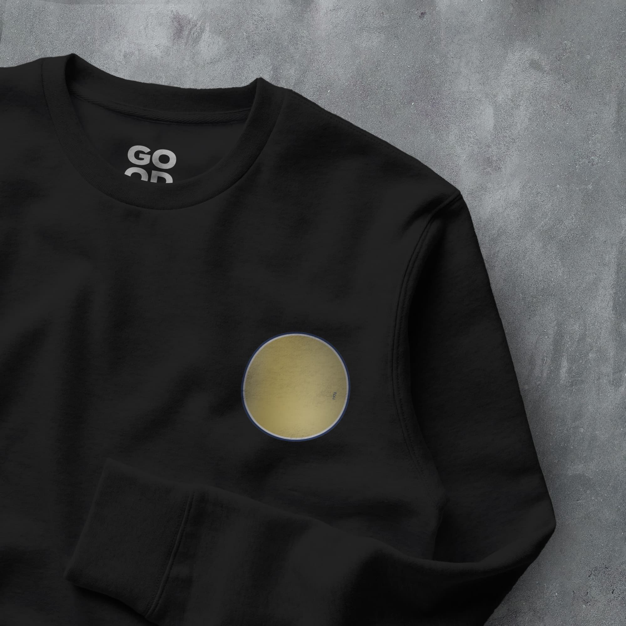 a black sweatshirt with a gold circle on it