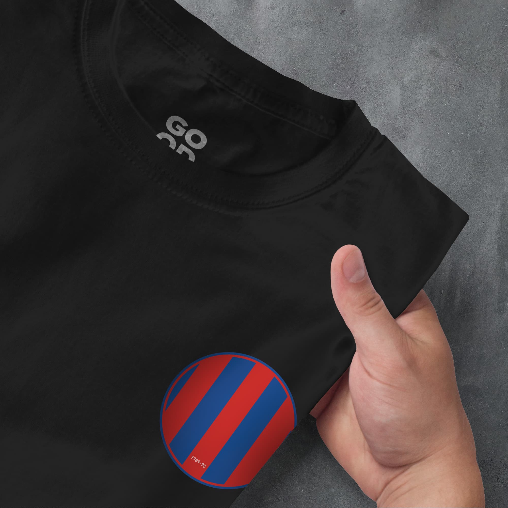 a hand pointing at a black shirt with a red and blue circle on it