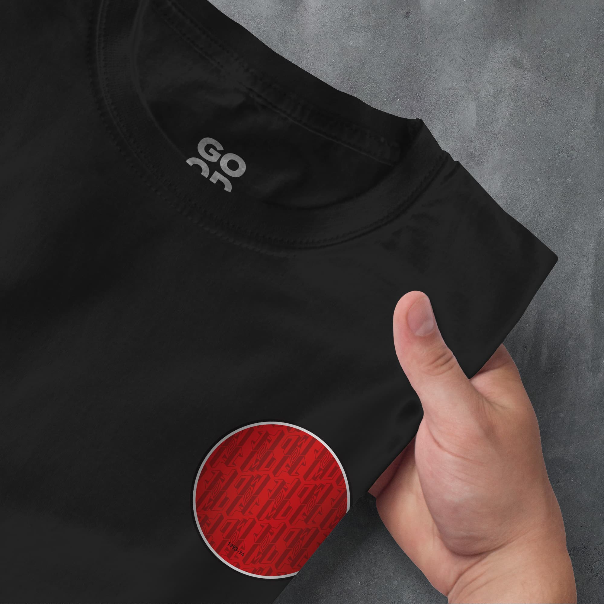 a person pointing at a black shirt with a red circle on it