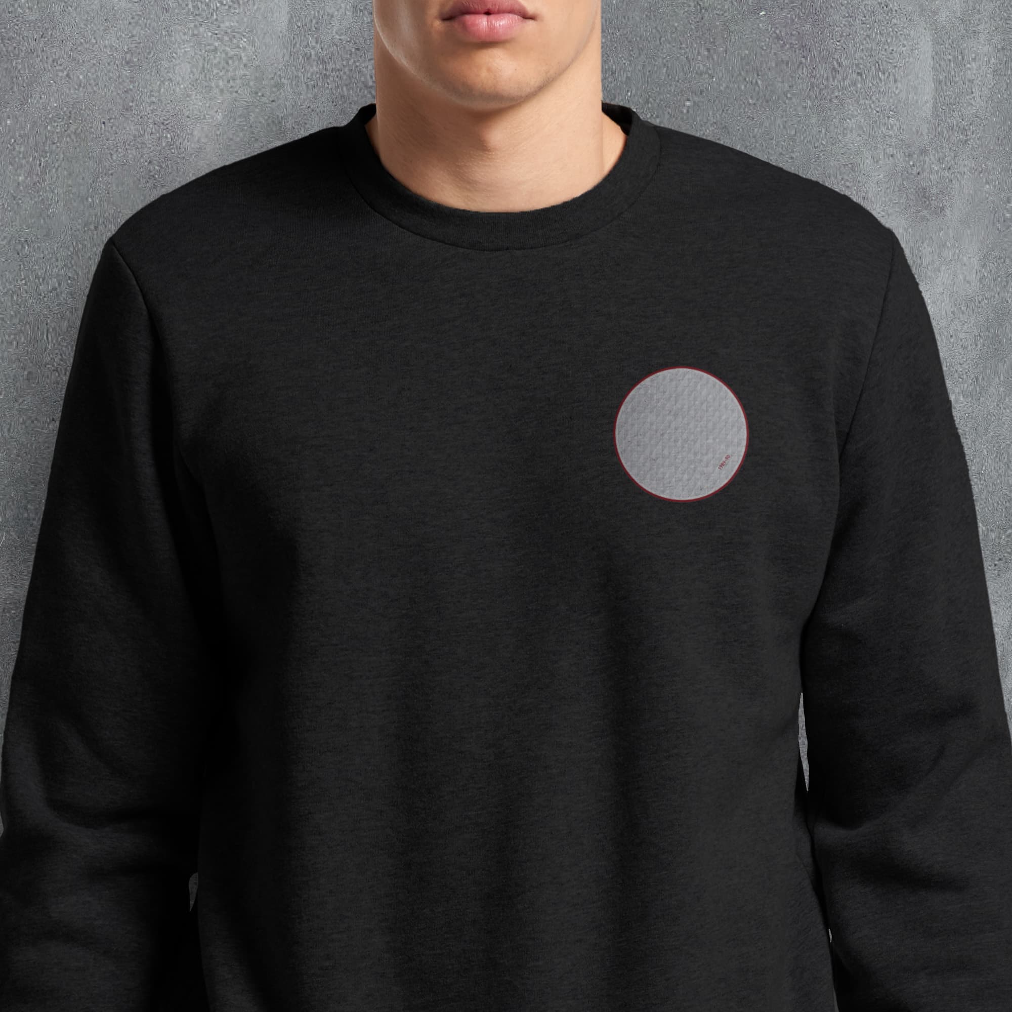 a man wearing a black sweatshirt with a grey circle on it