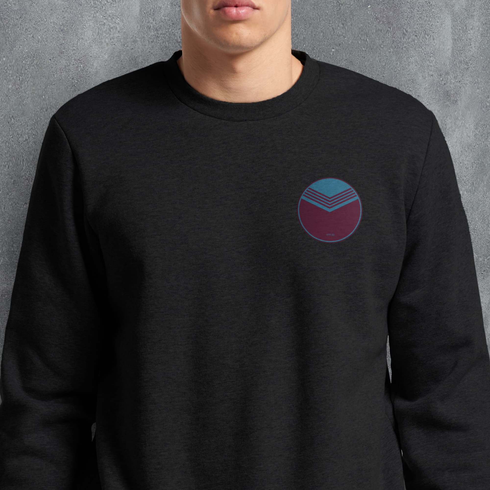 a man wearing a black sweatshirt with a blue and red circle on it