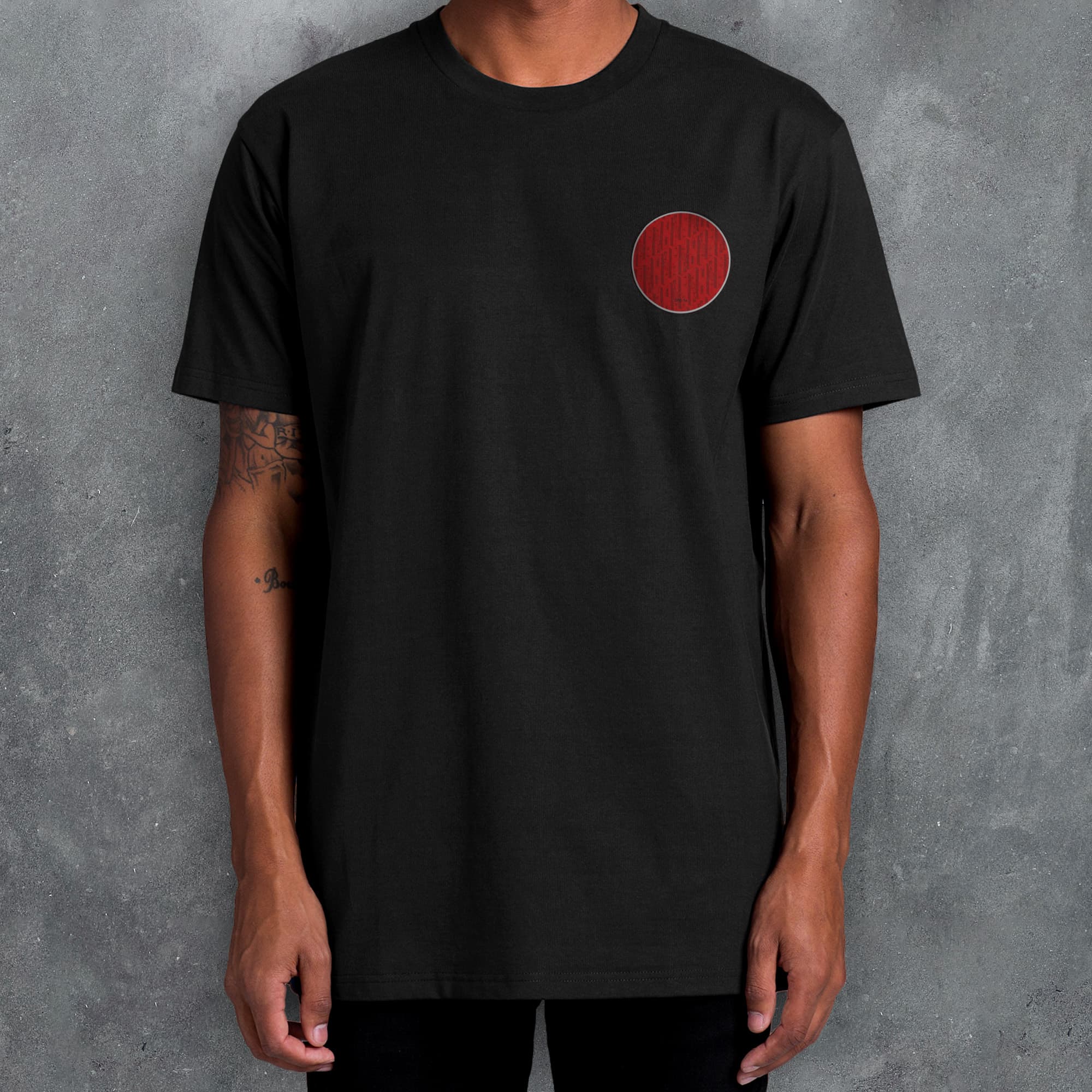 a man wearing a black shirt with a red circle on it