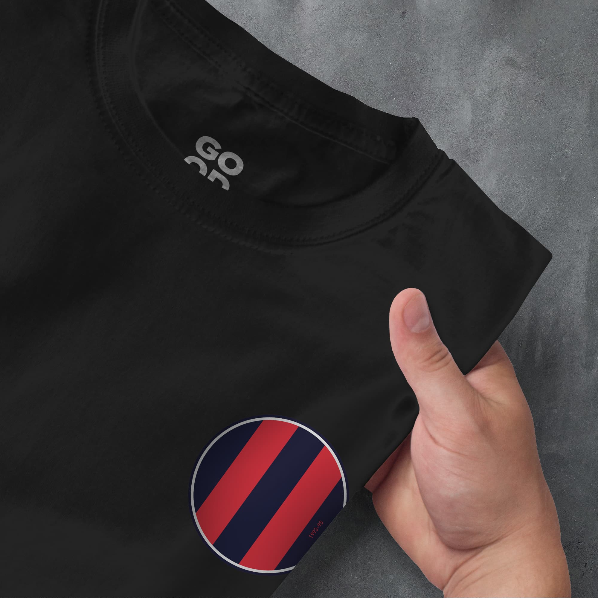 a hand pointing at a black shirt with red and blue stripes